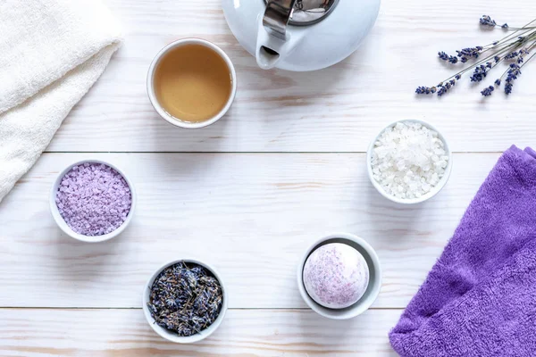 Ingredients for aromatherapy and spa,  aromatic sea salt, towels and Chinese tea. Natural cosmetics,  Spa kit for beauty and health on a white wooden background. Close up, top view, flat lay