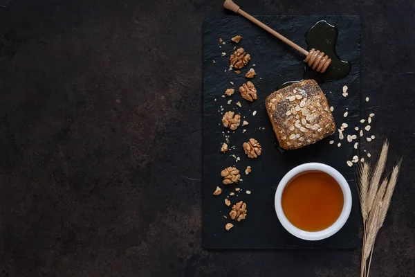 Glas kruka med fräsch naturlig honung, bröd och valnötter på en sten — Stockfoto