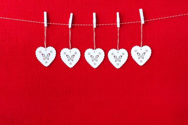 Kırmızı Kağıt arka plan üzerinde beyaz ahşap kalp simbols, yakın çekim