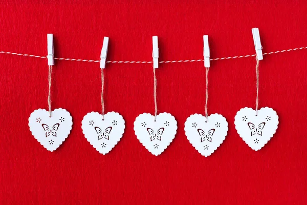 Nahaufnahme Von Weißen Hölzernen Herzsymbolen Auf Rotem Papier Hintergrund — Stockfoto
