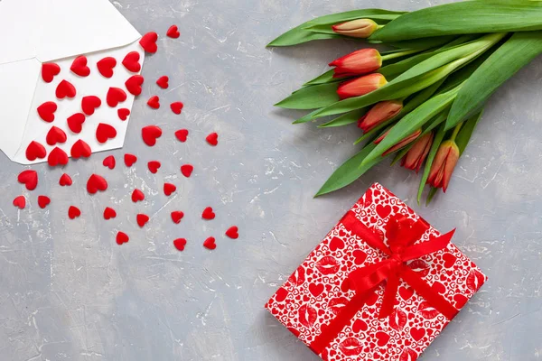 Rote Herzfiguren Papierumschlag Geschenkbox Mit Roter Schleife Und Rotem Tulpenstrauß — Stockfoto