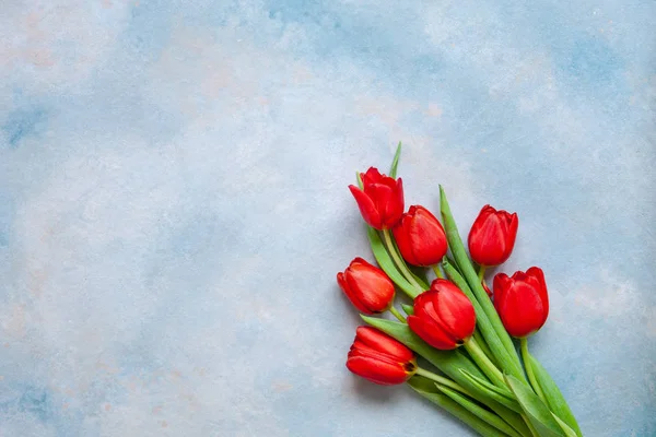 红色郁金香的花束 情人节 女性日和其他浪漫活动的概念 顶部视图 特写镜头 平面躺在蓝色背景 — 图库照片