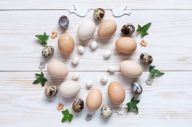 Paskalya dekorasyon desen doğal tavuk ve bıldırcın yumurtası. Görünüm sayfa, yakın çekim, düz beyaz ahşap zemin üzerinde yatıyordu