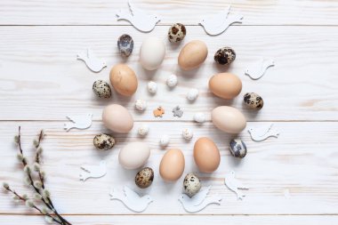 Paskalya dekorasyon desen doğal tavuk ve bıldırcın yumurtası. Görünüm sayfa, yakın çekim, düz beyaz ahşap zemin üzerinde yatıyordu