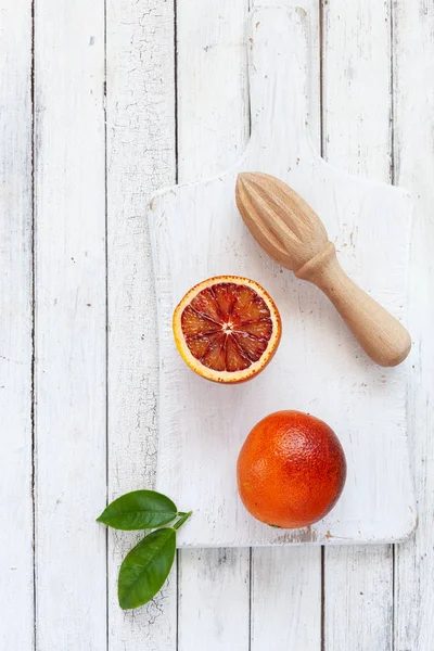 白い木製の背景に木製のジューサーで新鮮なブラッド オレンジ フルーツ — ストック写真