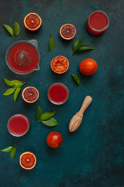 Frutas de laranja de sangue fresco e suco com espremedor de madeira e vidro — Fotografia de Stock