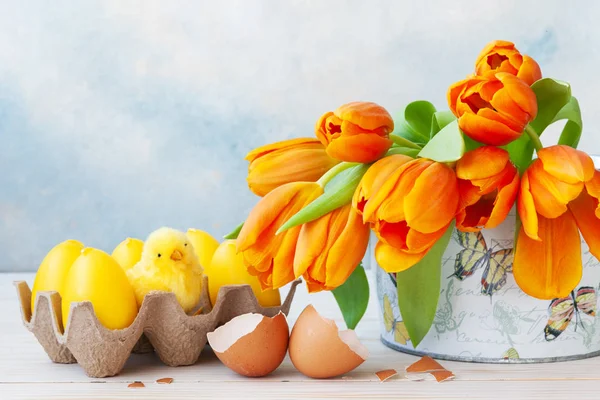 Букет з червоних тюльпанів, декоративних яєць і маленької курячої іграшки на — стокове фото
