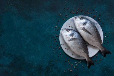 Mavi masada taş kesme tahtası üzerinde taze dorado balık. Üstten Görünüm