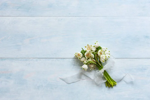 Bouquet di bucaneve su fondo di legno azzurro — Foto Stock