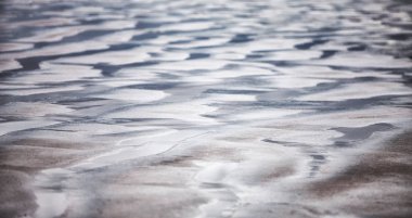   Kum plajda düşük tide - sudan oluşan desende