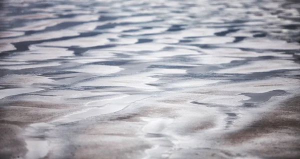   Kum plajda düşük tide - sudan oluşan desende