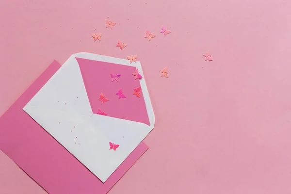 Farfalle rosa nella busta rosa sulla carta rosa — Foto Stock