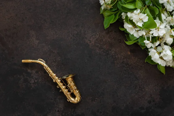 Little Golden saxophone and blossoming apple tree  branches. Top — Stock Photo, Image