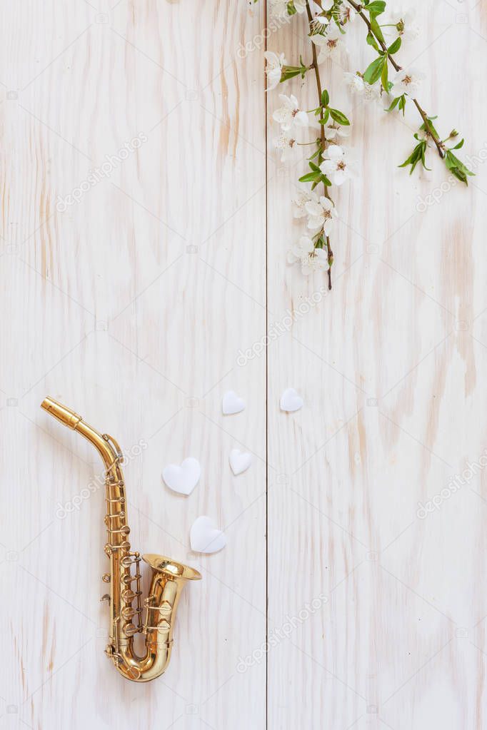 Little Golden saxophone, white heart shape figurines   and bloss