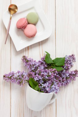 Beyaz fincan ve makaron taze kokulu leylak Buket