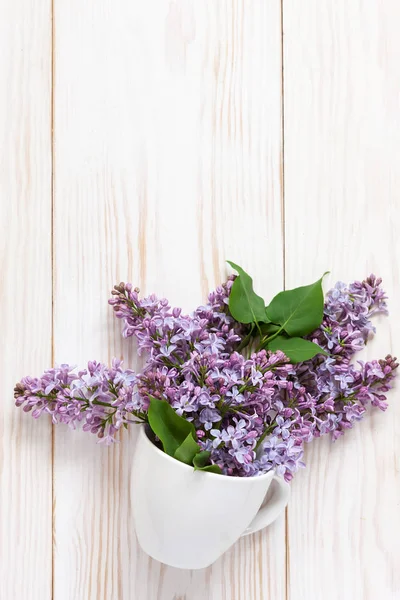 Un ramo de fresco fragante lila en una taza de porcelana blanca — Foto de Stock