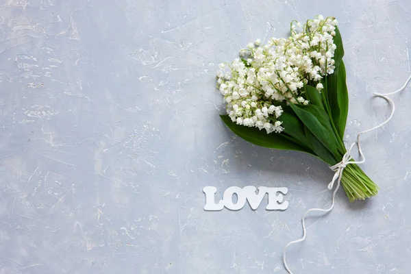 Bouquet von frischen duftenden Maiglöckchen auf blauem Hintergrund. — Stockfoto