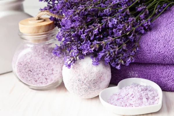 Flores de lavanda, jabón de lavanda, sal marina aromática y toallas . — Foto de Stock