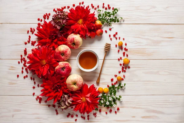 Apples, red dahlia flowers, pomergranate and honey — Stock Photo, Image