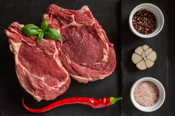 Steak segar mentah dengan tulang, rempah-rempah dan bumbu — Stok Foto