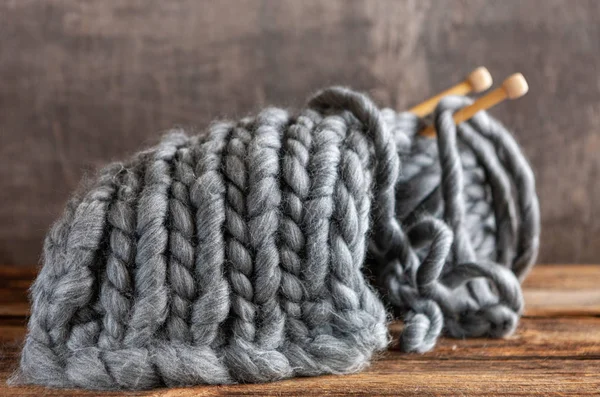 Knitting. Thick gray threads on wooden knitting needles. — Stock Photo, Image