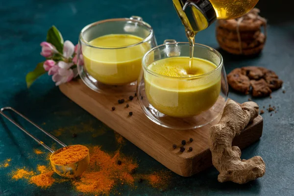 İki fincan ayurvedic, yeşil desenli, kakao tozu, zencefil ve ballı, altın sütlü zerdeçal latte..