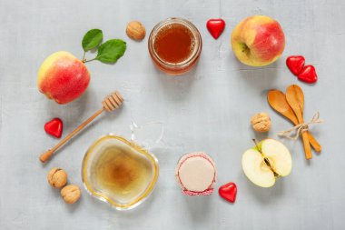 Apples, walnuts, and honey. Concept for Rosh Hashanah the Jewish New Year. Top view, close up on light gray background.	