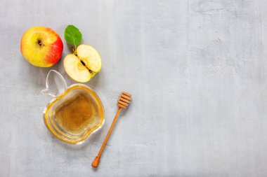 Apples and honey. Concept for Rosh Hashanah the Jewish New Year. Top view, close up on light gray background.	