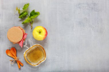 Apples and honey. Concept for Rosh Hashanah the Jewish New Year. Top view, close up on light gray background.	