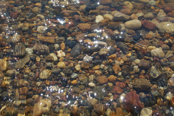 multi-colored stones in clear water /Photo of colored stones in the water.The water is clear, clearly visible bottom of the reservoir in the afternoon in the summer season.It's very beautiful.