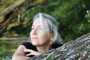 doğada sarışın bir kadın portresi / fotoğraf üzerinde düz tree.looks blonde.based genç bir woman.portrait,.