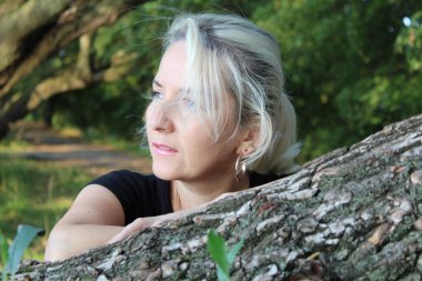 doğada sarışın bir kadın portresi / fotoğraf üzerinde düz tree.looks blonde.based genç bir woman.portrait,.