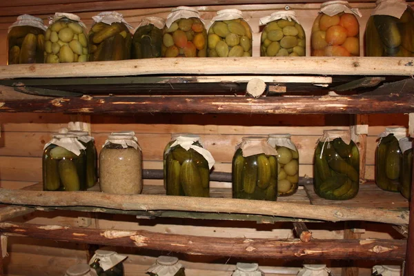 banks with pickles cucumbers, tomatoes, cabbage in storage / photo of large cans of pickles. in three-liter jars salted and pickled cucumbers, tomatoes, cabbage. they are in a special storage.are on the shelves.