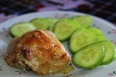 tavuk plaka dilim kızarmış et ve salatalık. / Fotoğraflar lezzetli yiyecek. kavrulmuş meat.chicken et bir plaka üzerinde. Ayrıca salatalık dilimlenmiş. Öğle Yemeği, akşam yemeği veya Breakfast.home yemek için lezzetli yemekler.
