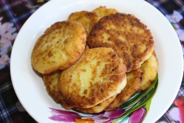 kızarmış süzme peynirli cheesecakes bir tabak / fotoğraf köy peynircheesecakes.onlar ocakta pişirilir.tavada kızarmış.bir tabakta süzme peynir cheesecakes.lezzetli ev yapımı gıda.