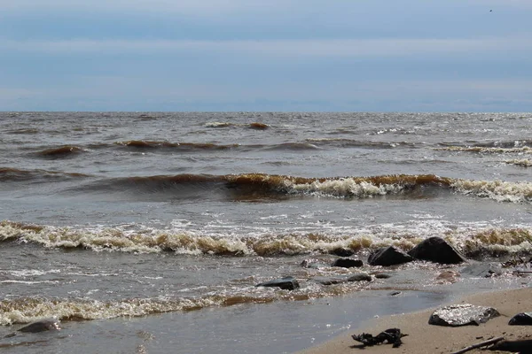 风景如画的大湖 暑假有波浪 照片一个巨大的湖 水与高波 在泡沫的波峰上 岩石和砾石在沙滩上 草是绿色的 舒适的海滩娱乐 时间年夏季 天空是蓝色的 — 图库照片