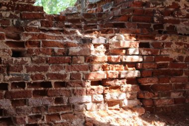 zaman zaman eski tapınağın tuğla duvarları yok / fotoğraf duvar.duvar eski, tahrip.kırmızı tuğla.zaman kilise yok etti.tarihi bir binanın antik kalıntıları.mavi gökyüzüne karşı.yeşil çalılar etrafında .zaman yıl yaz.gün.