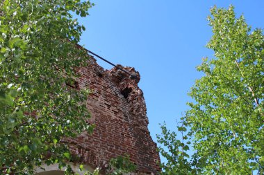 zaman zaman eski tapınağın tuğla duvarları yok / fotoğraf duvar.duvar eski, tahrip.kırmızı tuğla.zaman kilise yok etti.tarihi bir binanın antik kalıntıları.mavi gökyüzüne karşı.yeşil çalılar etrafında .zaman yıl yaz.gün.