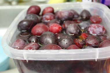 meyve suyu içinde erik / taze erik fotoğrafı.meyve suda ıslatılır.yemek için çilek hazırlanması, su ve ıslatılmış meyve ağacı kabı jam.in pişirme.