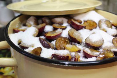 reçel tenceresinde şeker li taze erik / şekerli taze erik fotoğrafı .meyveler tavada.meyve yarıya indirilir.taş çıkarılır.böğürtlenler şekerle katmanlara konur.reçel pişirmeye hazırlanır.