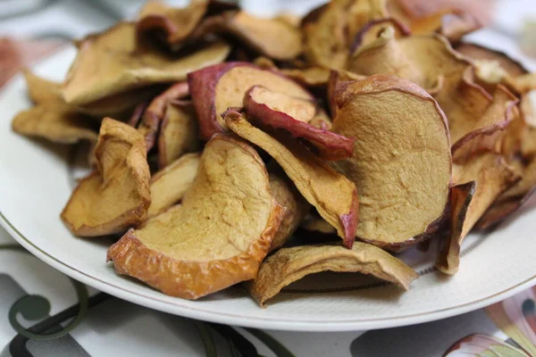 apples fruits dried at home in summer / photo of dried fruits close-up. apples dried in the home kitchen. they are on a plate on the table.