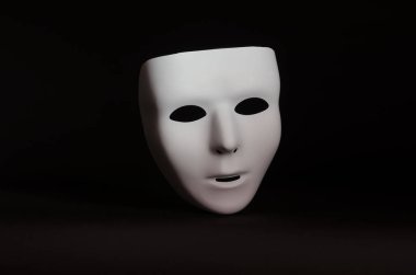 boş, duygusuz bir maskeli maske yalın siyah bir arka plan karşı vurgulanır 