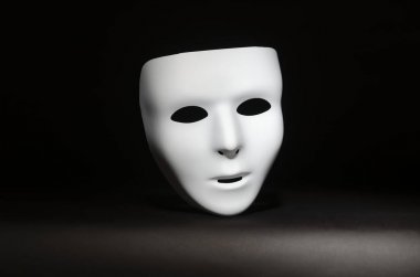 boş, duygusuz bir maskeli maske yalın siyah bir arka plan karşı vurgulanır 