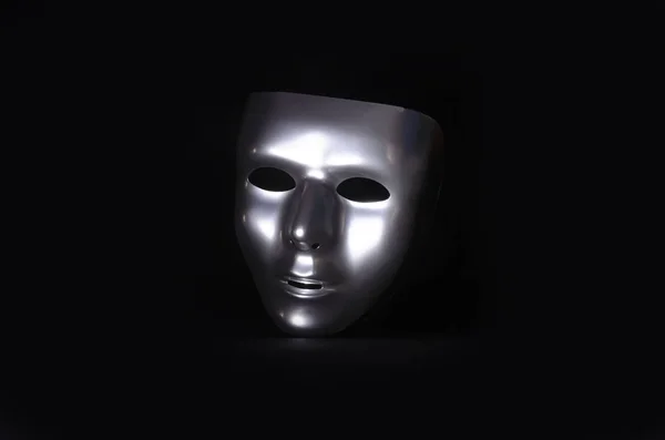 Uma Máscara Metálica Brilhante Destacada Contra Fundo Preto Partida — Fotografia de Stock