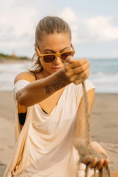 Mooie Vrouw Casual Kleding Houten Zonnebrillen Kijken Naar Het Zand — Stockfoto