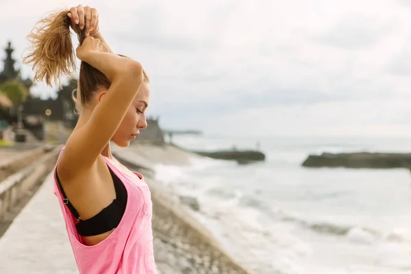 すぐスポーツ夏服のきれいな女性の肖像画を修正し 彼女の髪を設定します 海ビーチの夕日や海の日の出にセクシーな女性 アクティブなヨガや瞑想ライフ スタイル コンセプト — ストック写真