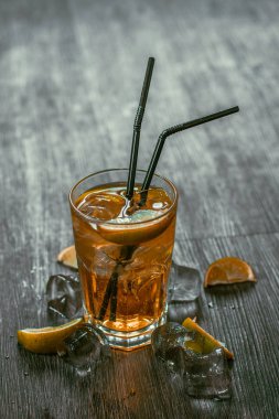 Lezzetli alkollü kokteyl limon ve kireç, ahşap arka plan üzerinde buz parçaları