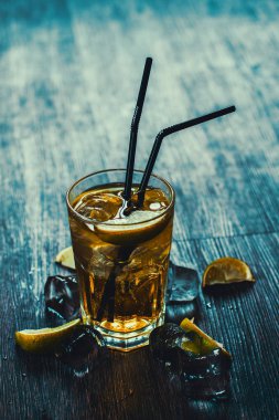 Lezzetli alkollü kokteyl limon ve kireç, ahşap arka plan üzerinde buz parçaları