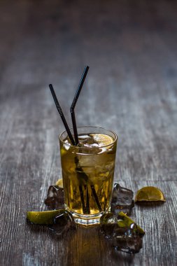 Lezzetli alkollü kokteyl limon ve kireç, ahşap arka plan üzerinde buz parçaları