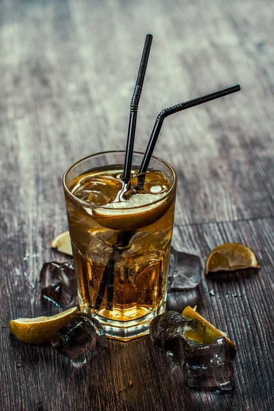 Lezzetli alkollü kokteyl limon ve kireç, ahşap arka plan üzerinde buz parçaları
